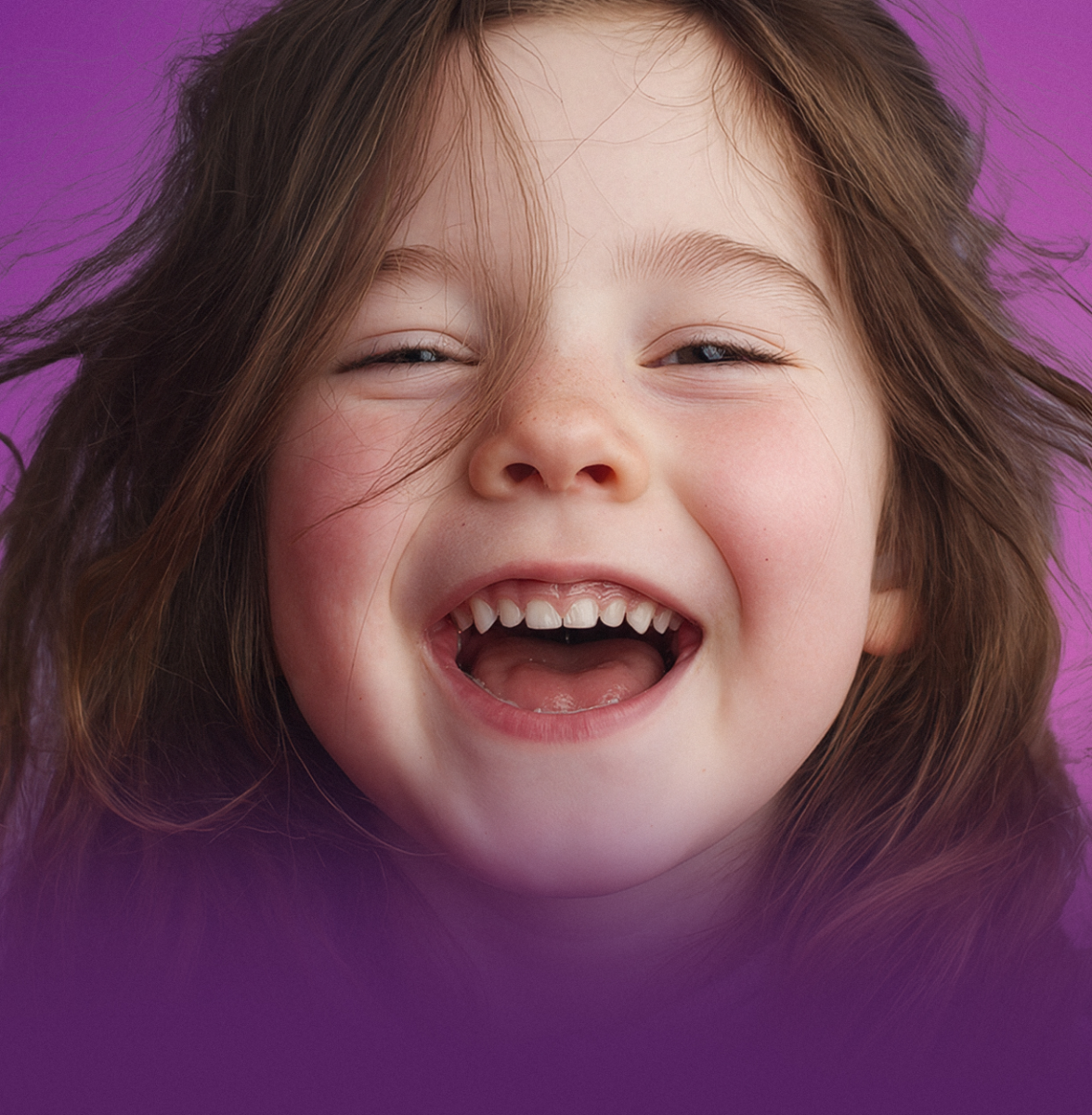 A laughing young girl with long brown hair.