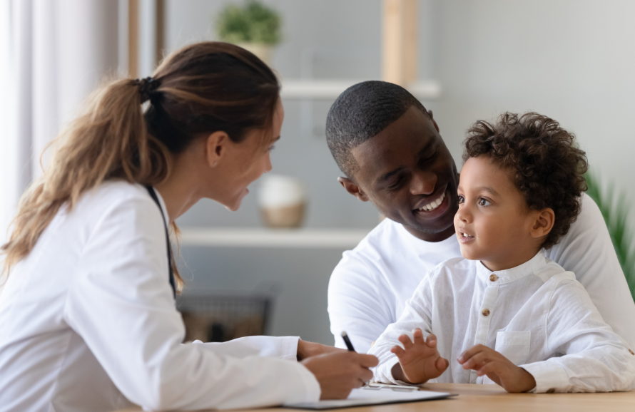 A healthcare professional meets with a caregiver and his child.