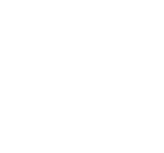 A young boy smiling with his hands under his chin.